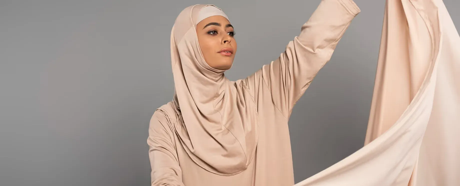 A flat lay of folded chiffon scarves in neutral tones